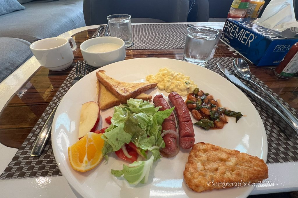 フレンチトースト、スクランブルエッグ、ソーセージ、豆料理、ハッシュブラウン、サラダを盛った朝食
